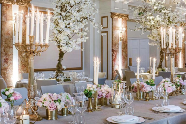 Tables set with gold candelabra, white blossom, pink roses and crystal glassware for an evening dinner, Kimpton Fitzroy London