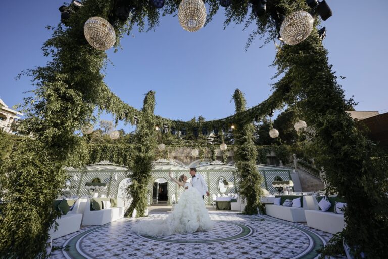 A wedding ceremony space ringed with greenery and flowers, KM Events