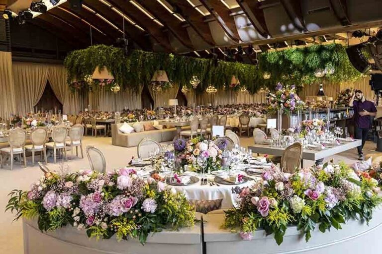 A reception hall with pink and lilac flower displays, KM Events