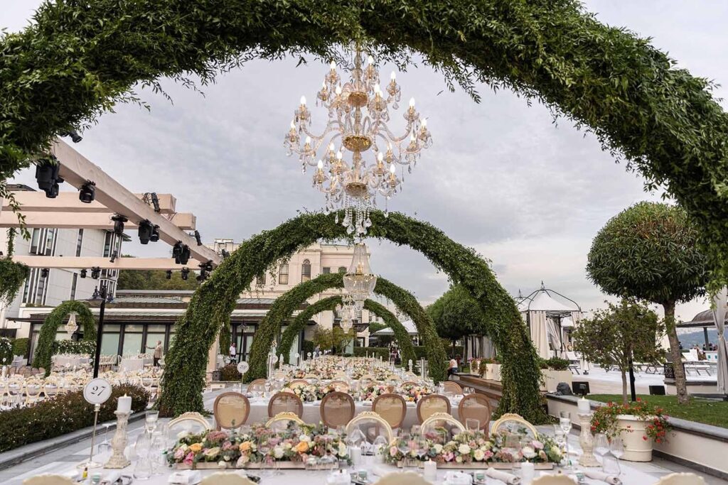 A seafront ceremony with green arches and chandeliers, KM Events