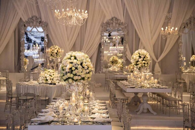 A cream draped reception with white flower centrepieces, KM Events
