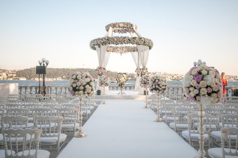 A beach-style ceremony aisle with a floral canopy, KM Events