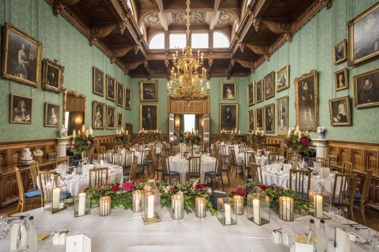 The State Dining Room set with round tables beneath a chandelier, Knowsley Hall