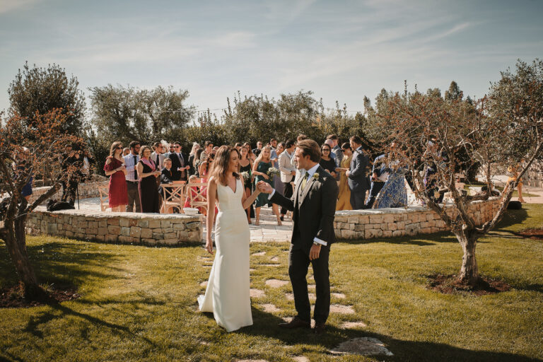 The couple walking through an olive grove after the ceremony, Puglia, La Bottega del Sogno