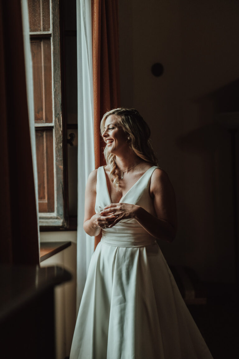 The bride at a shuttered window before the ceremony, Tuscany, La Bottega del Sogno