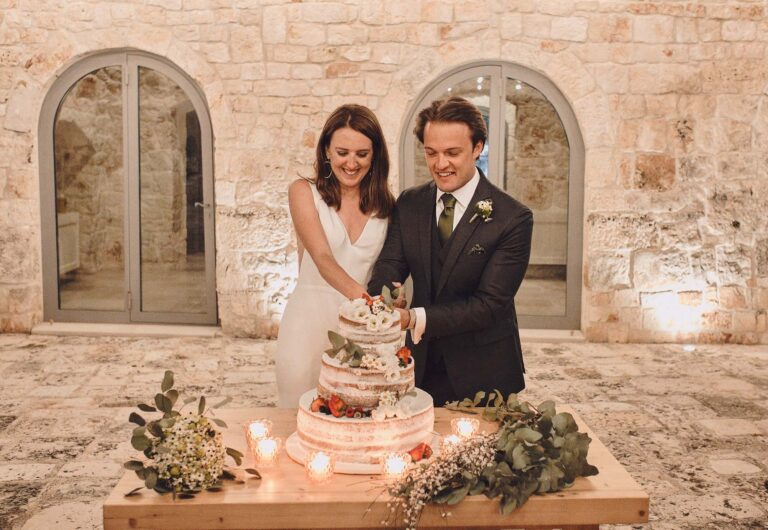 Cutting the cake by candlelight in a stone courtyard, La Bottega del Sogno