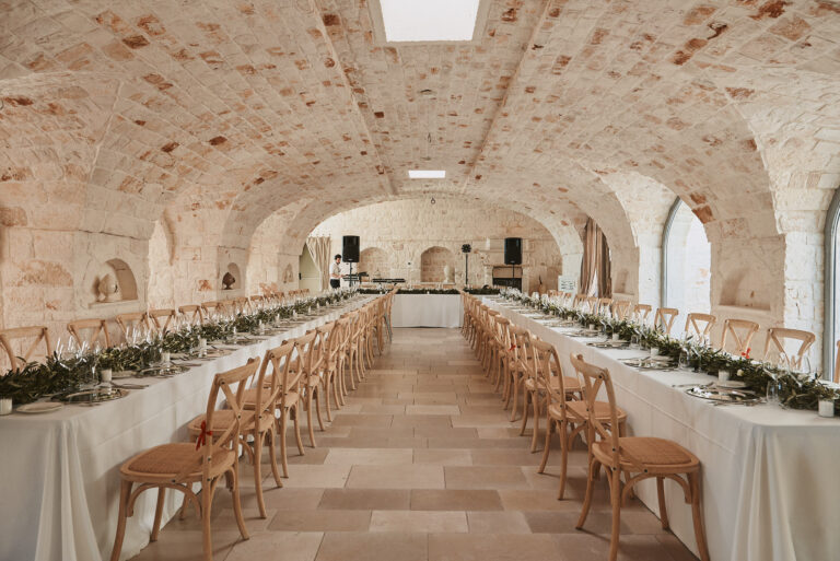 A long wedding breakfast laid beneath a vaulted stone hall, Puglia, La Bottega del Sogno
