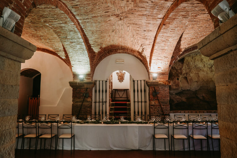 A vaulted cellar dining room set for the wedding dinner, Tuscany, La Bottega del Sogno