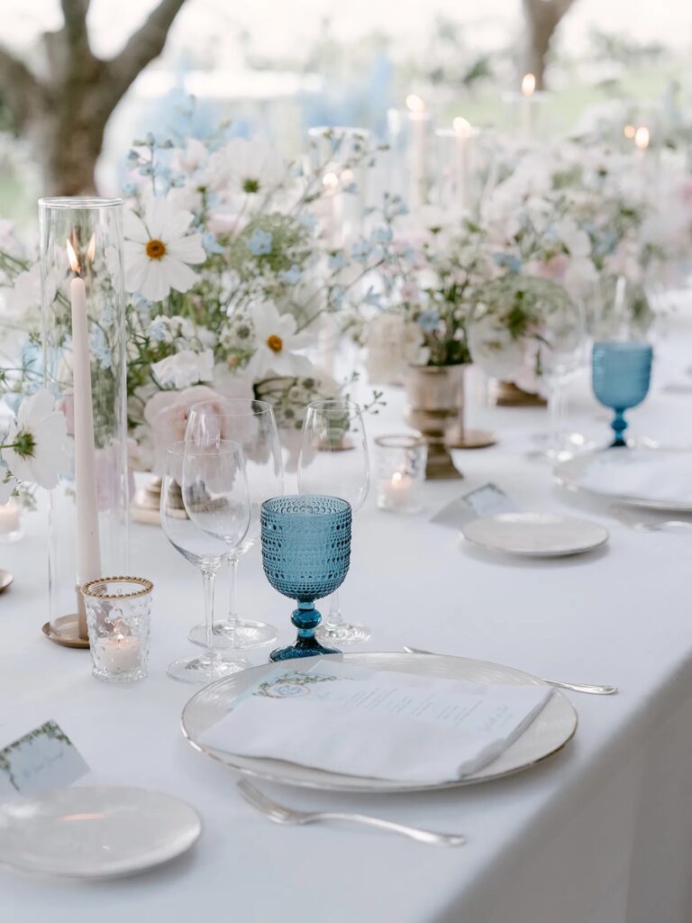 A table of white daisies, blue glassware and tapers, Belmond Hotel Caruso, Ravello, La Calla Events