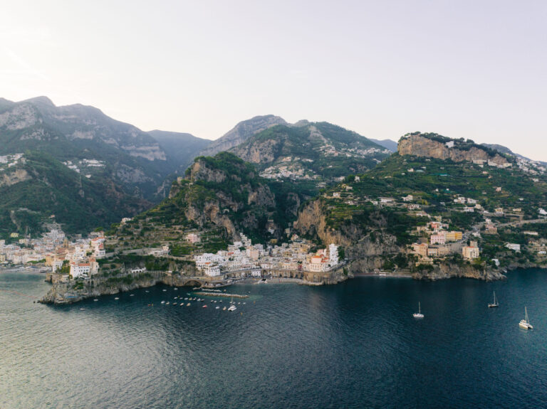 The Amalfi Coast from the air at dusk, towns stacked along the shore, La Calla Events