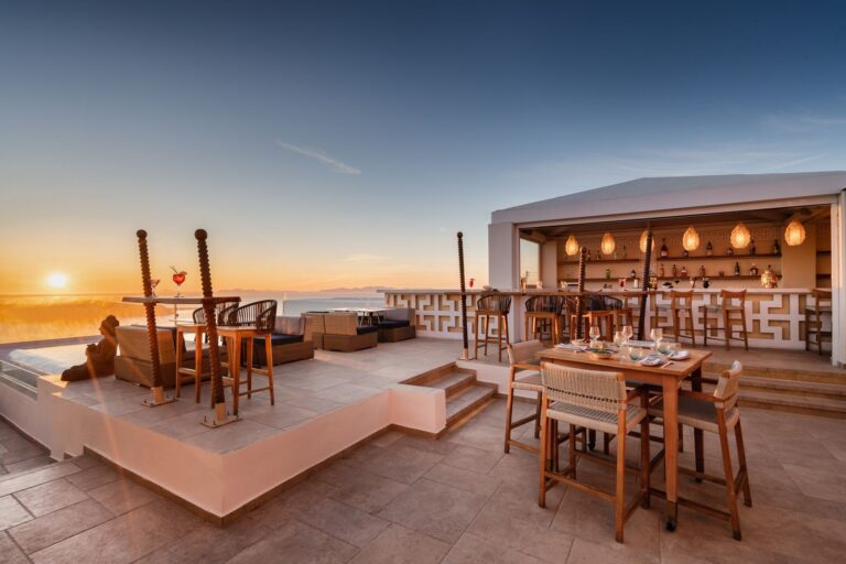 The rooftop bar and dining terrace at sunset, tables set above the sea at the sister Buddha-Bar Beach, La Maltese Estate