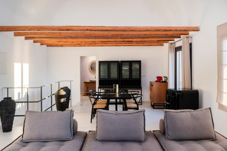 A suite dining area under restored timber beams, a black oak table and glazed cabinets, La Maltese Estate