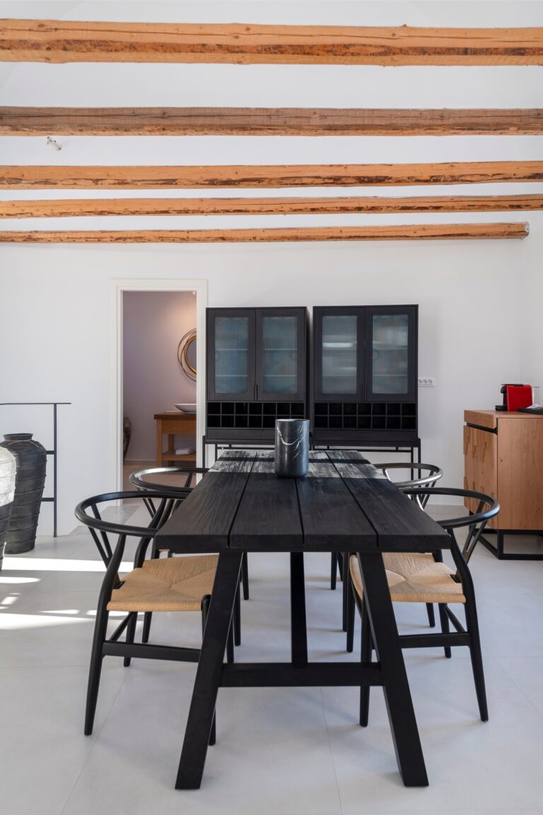 A suite dining room, a black oak table and woven chairs beneath century-old beams, La Maltese Estate