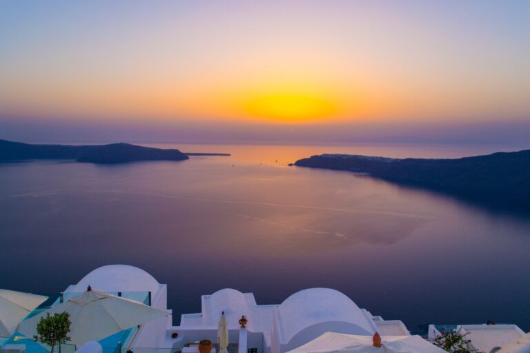 The Santorini caldera at sunset, white domes above the sea, La Maltese Estate