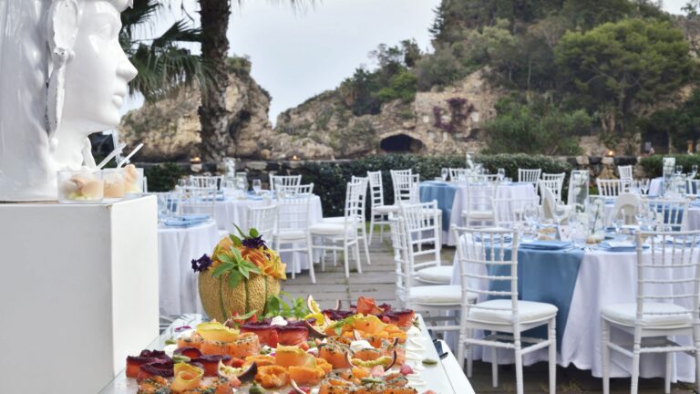 A wedding buffet on the beach club terrace, fruit and antipasti with the bay behind, La Plage Resort