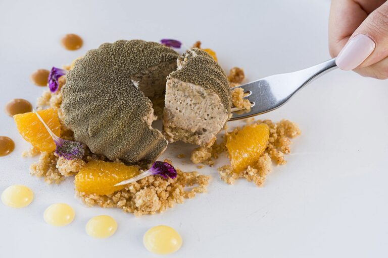 A plated dessert, hazelnut and orange, at Idda, La Plage Resort