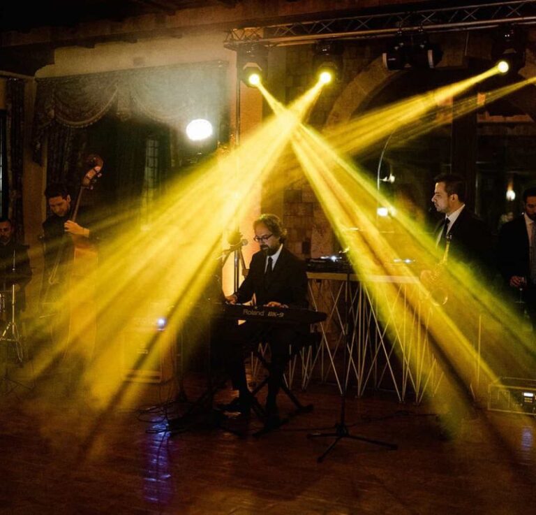 Stage lights sweeping over a live band in a historic room, La Semicroma