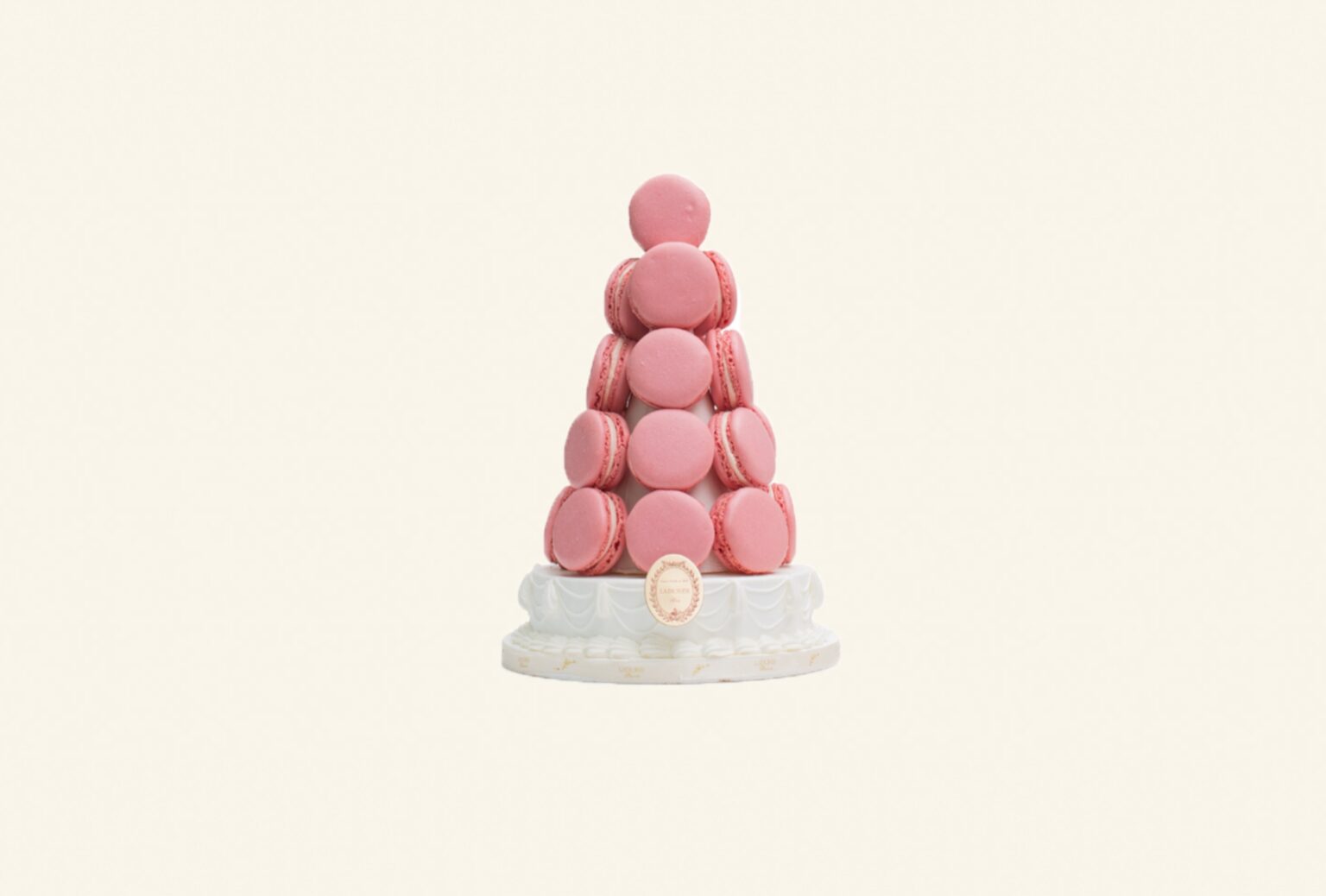 A pyramid of rose and ivory macarons on a porcelain stand