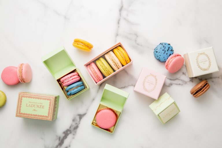 Flat lay of small macaron boxes and loose macarons, Ladurée
