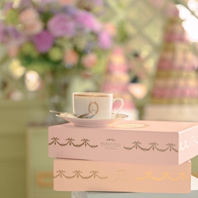 Pink macaron boxes and tea with a pyramid in the background, Ladurée