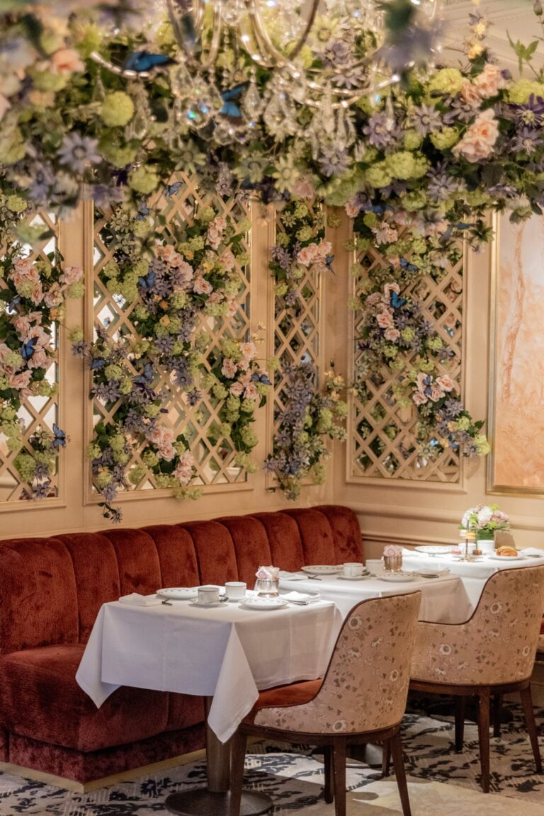 Tea room with a wall of flowers and set tables, Ladurée