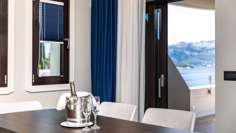 A suite table set with champagne on ice, the sea framed in the window beyond, Lafodia Sea Resort