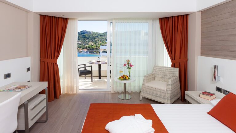 A Premium room opening onto a private terrace with a table set above the water, Lafodia Sea Resort