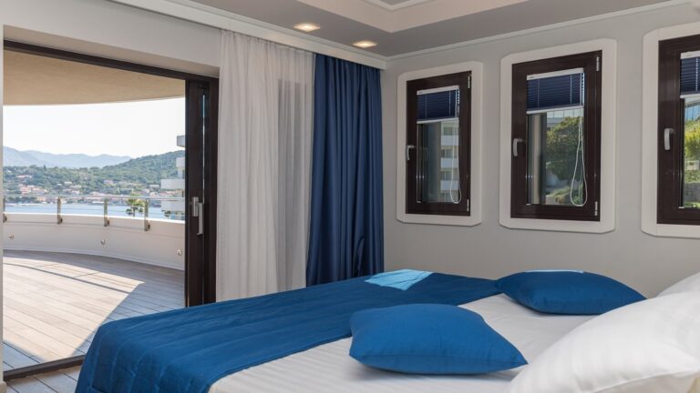 A Lazure Presidential suite bedroom in navy and white, opening onto a broad sea-view terrace, Lafodia Sea Resort