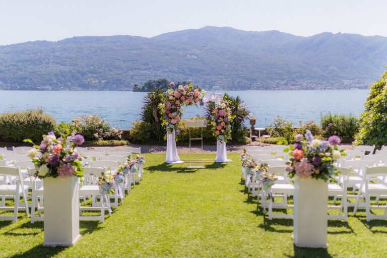 A pastel arch of hydrangea and roses on a lakeside lawn, flower urns on white plinths along the aisle, Lake Maggiore, Lake Maggiore & Tuscany Weddings