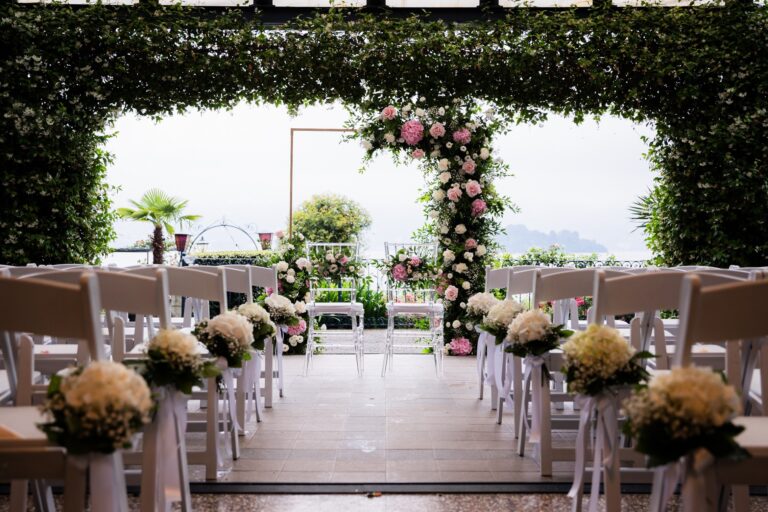 Ceremony chairs under a jasmine-covered pergola, a pink and cream rose arch and gypsophila posies on each aisle chair, Lake Maggiore, Lake Maggiore & Tuscany Weddings