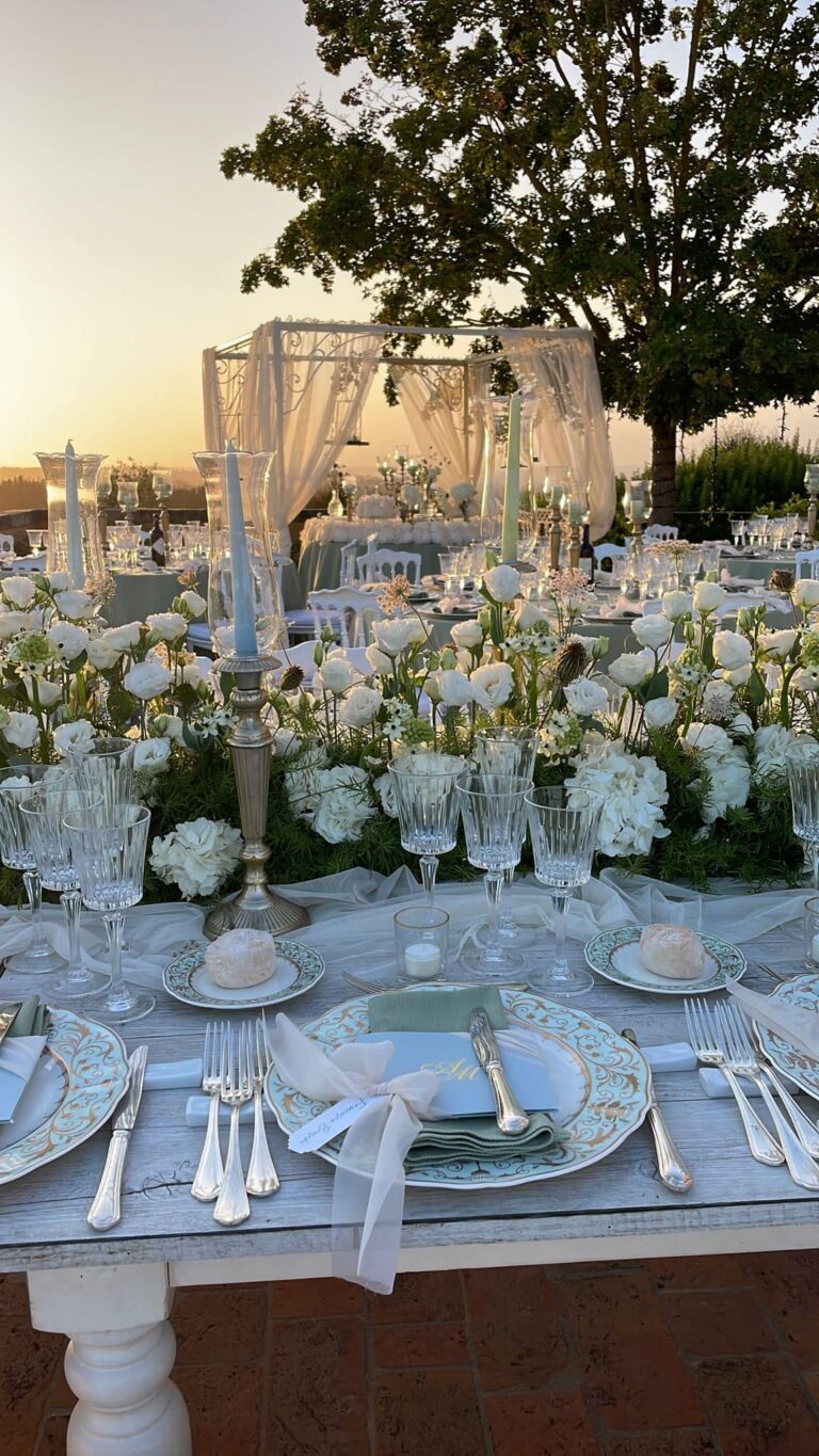 A long table above the lake at sunset with candelabra, massed white roses and a draped canopy beyond, Lake Maggiore, Lake Maggiore & Tuscany Weddings