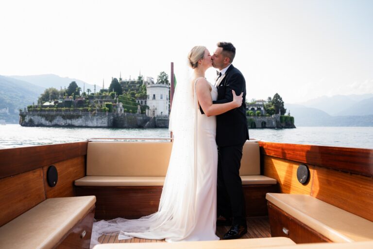 The couple in a wooden launch on the lake with the terraced gardens of Isola Bella behind, Borromean Islands, Lake Maggiore & Tuscany Weddings