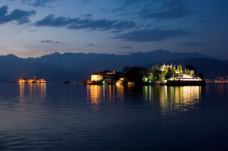 The Borromean Islands lit at dusk seen from the water, the mountains dark behind, Lake Maggiore, Lake Maggiore & Tuscany Weddings