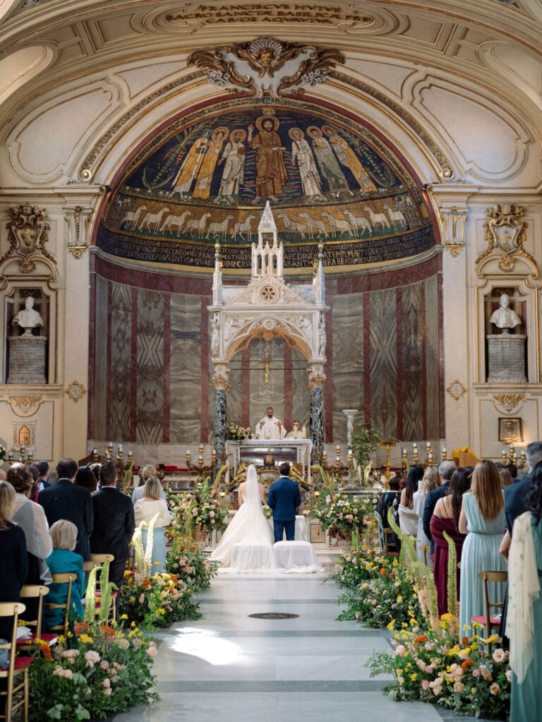 A church ceremony beneath a gold mosaic apse, the aisle lined with garden-style flowers, Le Rêve