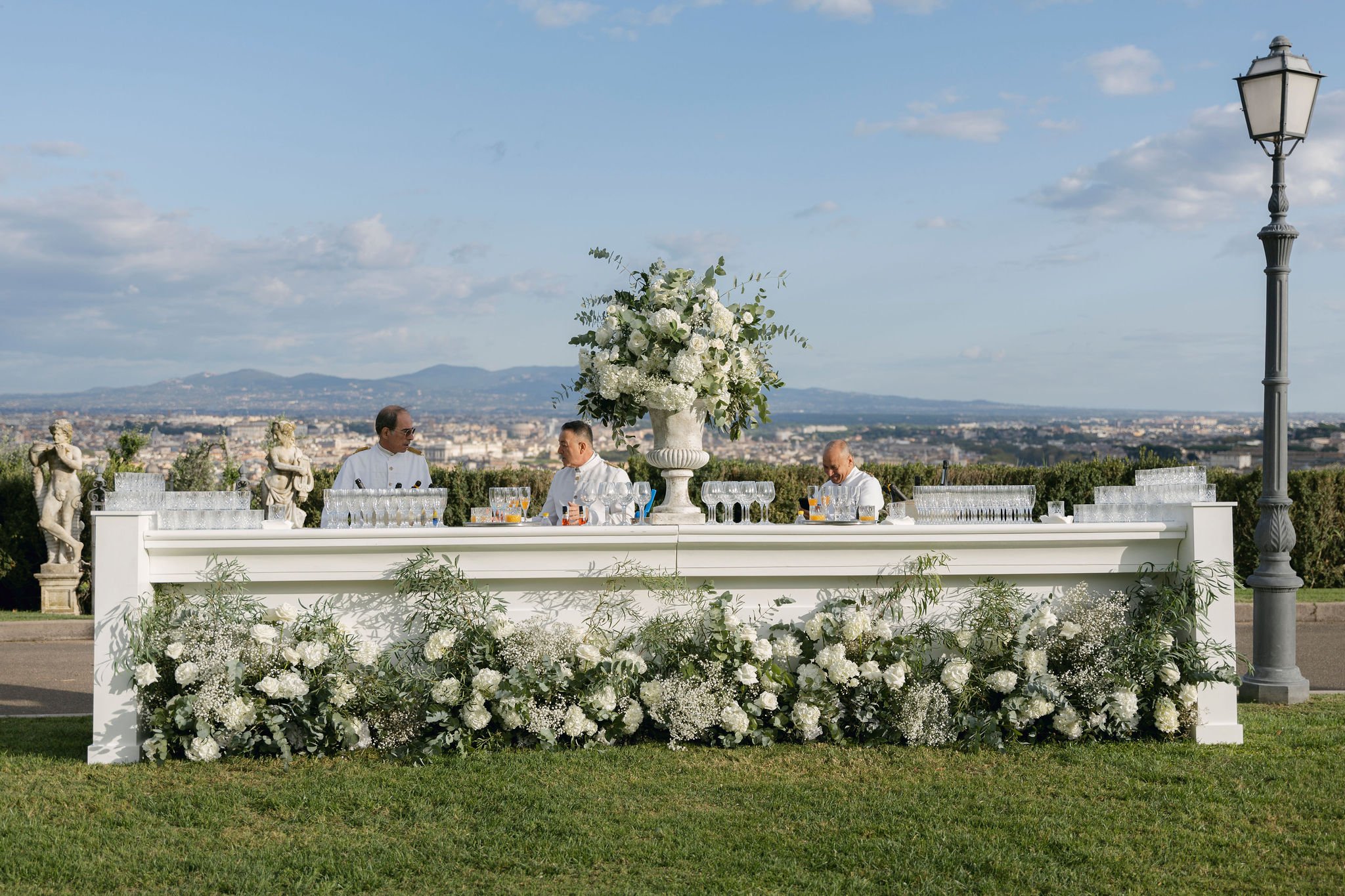 A long table banked with white flowers on the lawn at Villa Miani, Rome, the city spread out below, Le Rêve