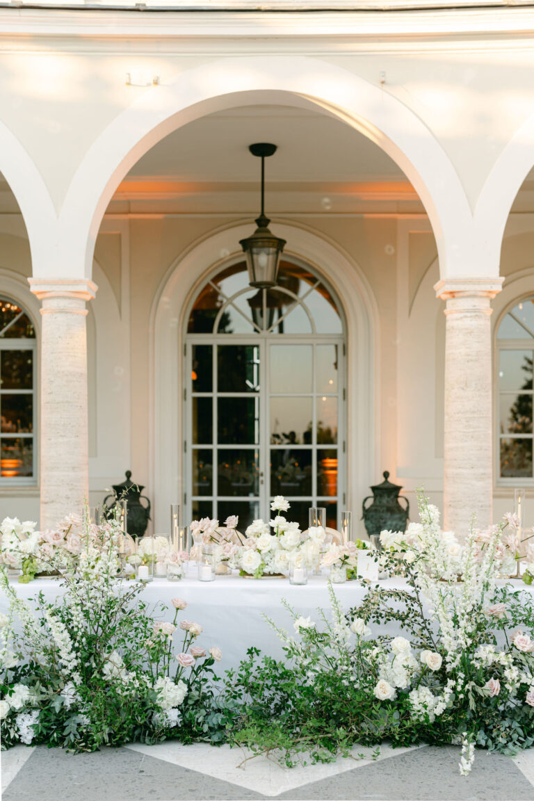 A head table under a lit arcade, dressed with low meadows of white flowers, Le Rêve