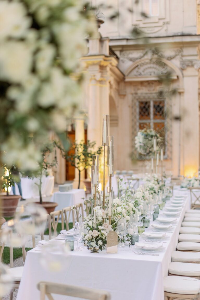 A long white table with small vases of white flowers in the garden at Villa Aurelia, Rome, Le Rêve