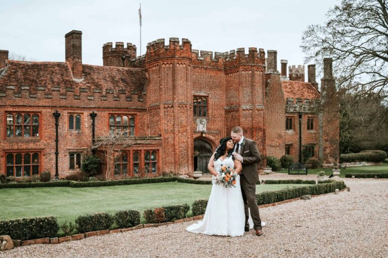A winter portrait of the couple on the gravel drive before the Tudor mansion and its gardens, Leez Priory