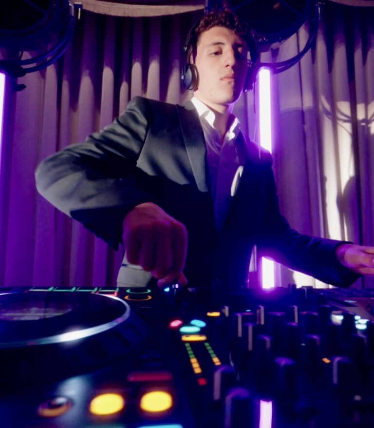 A DJ at the decks against a purple curtain, Les Cigales