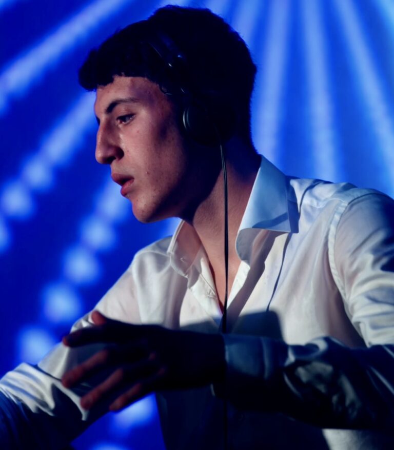 A DJ wearing headphones in blue light, Les Cigales