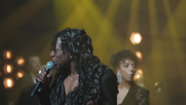 Two singers on a green-lit stage, Les Cigales