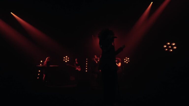 A singer silhouetted against red spotlights, Les Cigales