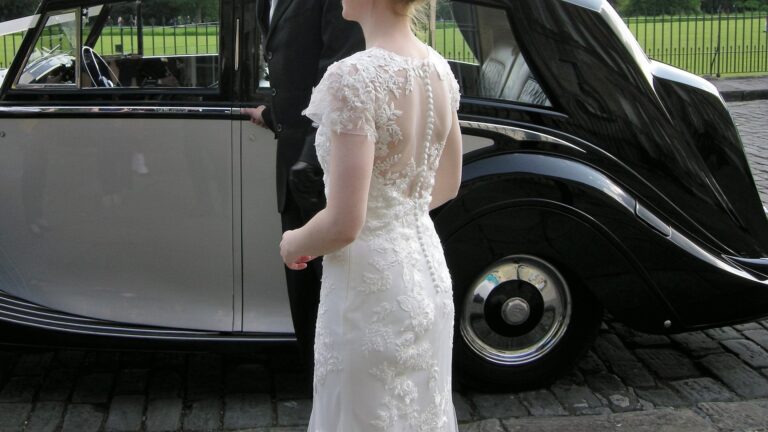 Back of a lace wedding dress beside a vintage car, Lesley Cutler Bridal Wear