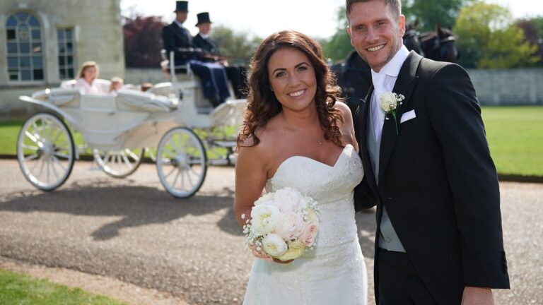 Bride and groom in front of a white carriage, Lesley Cutler Bridal Wear