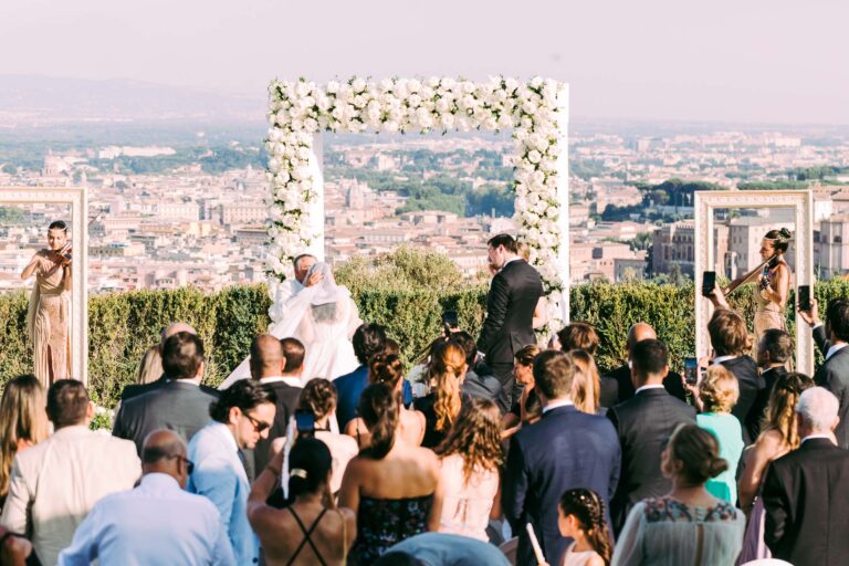 The ceremony at Villa Miani, Rome, with the city spread out beyond the flower arch, Light & Dreams