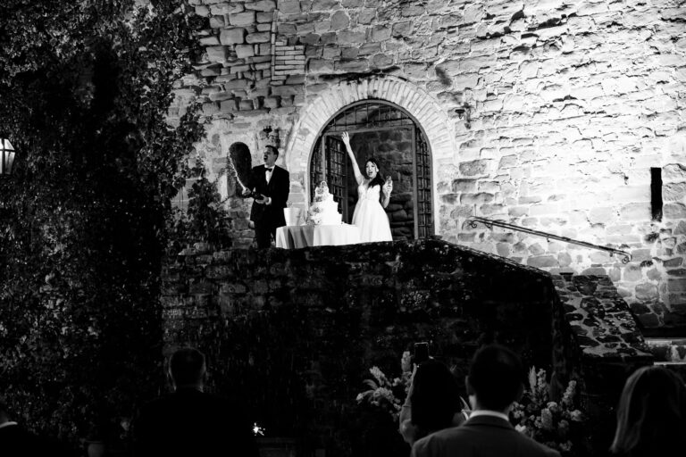 In black and white: the couple at the cake under the castle walls at night, Castello di Rosciano, Umbria, Light & Dreams