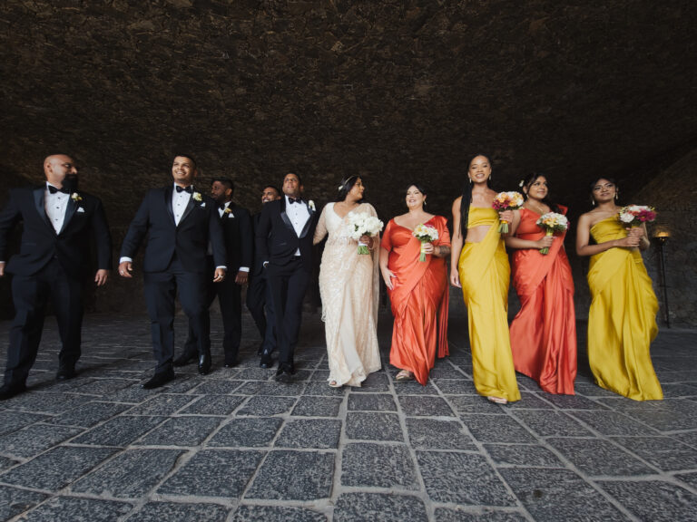 A bridal party in saffron and gold walking through a stone courtyard, Sri Lanka, Lights and Magic