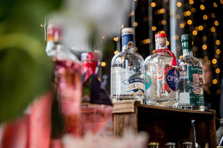 Gin bottles and glassware on the bar, with fairy lights behind, Lillibrooke Manor