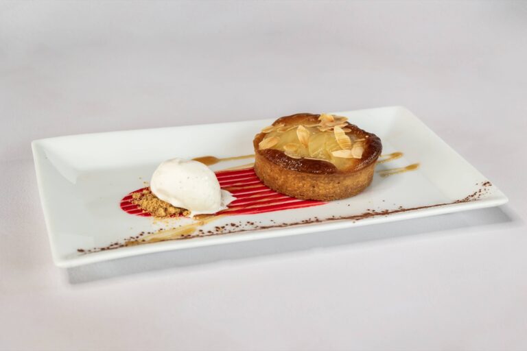 A plated almond tart with ice cream and a red berry sauce, Lillibrooke Manor