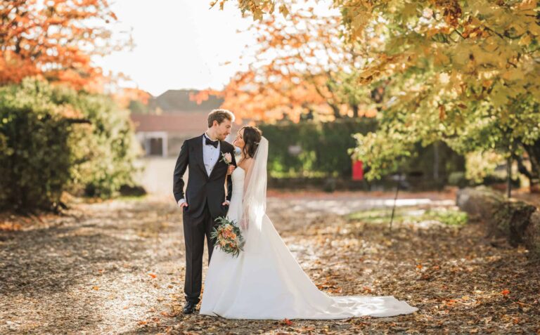 A couple under autumn trees on the leaf-strewn drive, Lillibrooke Manor